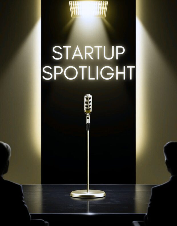 Neónový nápis Startup Spotlight nad mikrofónom, v popredí siluety poroty